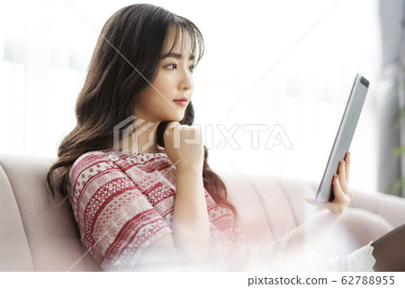 A young lady with a smartphone on the sofa 62788955