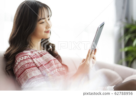 A young lady with a smartphone on the sofa A young lady with a smartphone on the sofa 62788956