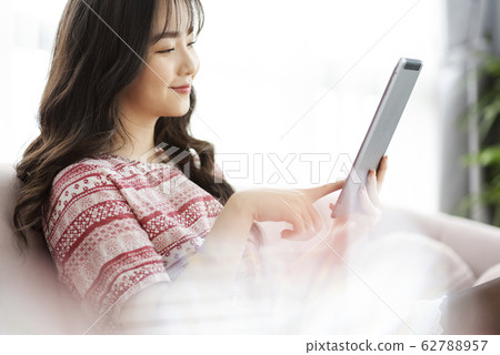 A young lady with a smartphone on the sofa 62788957