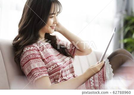 A young lady with a smartphone on the sofa A young lady with a smartphone on the sofa 62788960