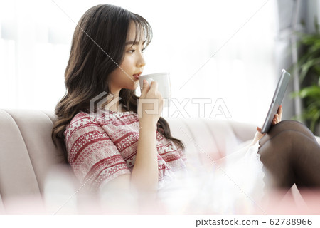 A young lady with a smartphone on the sofa 62788966