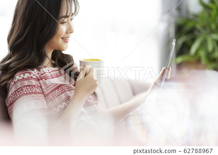 A young lady with a smartphone on the sofa 62788967