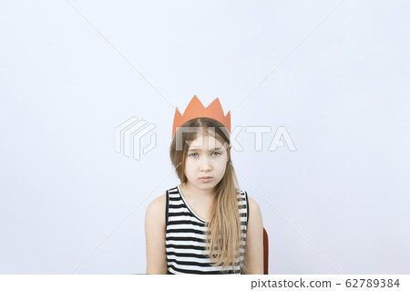 Sad young teenager girl in red crown 62789384