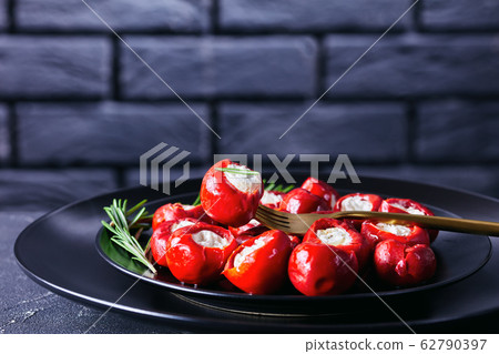 Cherry peppers with cheese in front of brick wall Cherry peppers with cheese in front of brick wall 62790397