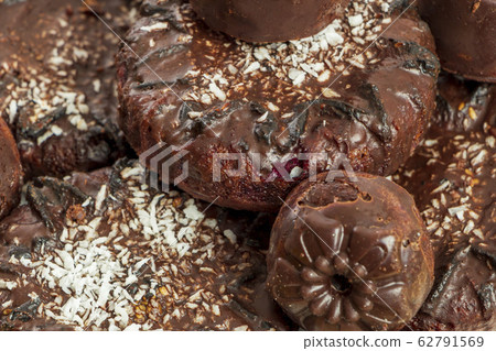 Background of homemade chocolate sweets. Natural chocolate candies. Coconut raisin cookies. Top view. Selective focus. Healthy and delicious meal. Harmless treat to tea for vegan and vegetarian diet 62791569