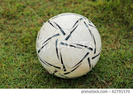 Old ball on grass 62791570