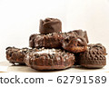 Delicious chocolate dietary treats for vegans made from natural ingredients. Candy and raisin cookies, sprinkled with coconut, on a white plate. Light background with place for text. Selective focus 62791589