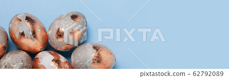 Easter minimalistic concept. Golden eggs on a blue background Easter minimalistic concept. Golden eggs on a blue background 62792089