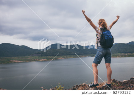 Happy woman standing near the lake at the day 62793122