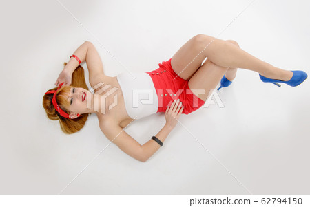 Sexy pin-up girl in shorts and high heels lying on Sexy pin-up girl in shorts and high heels lying on 62794150