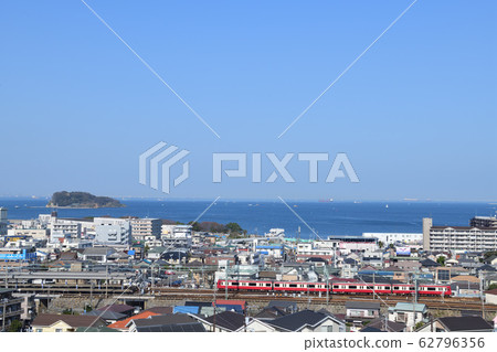View of Keikyu's red train from the hill overlooking Uraga Suido and Sarushima Island 62796356