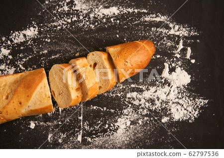 one sliced french baguettes lie on an old wooden one sliced french baguettes lie on an old wooden 62797536