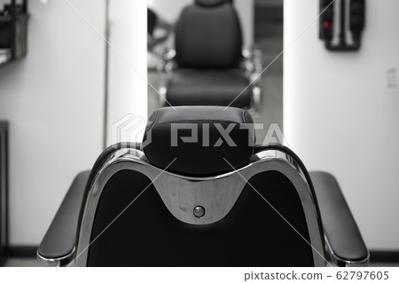 Classic vintage barber chair stands opposite Classic vintage barber chair stands opposite 62797605
