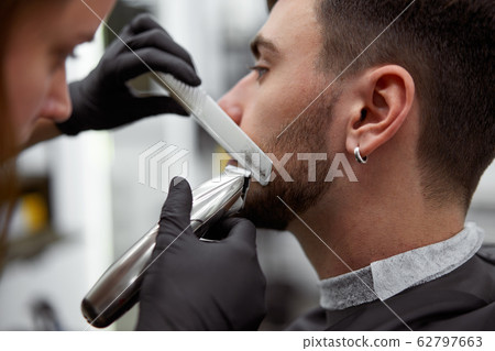 Young beautiful caucasian woman hairdresser cuts Young beautiful caucasian woman hairdresser cuts 62797663