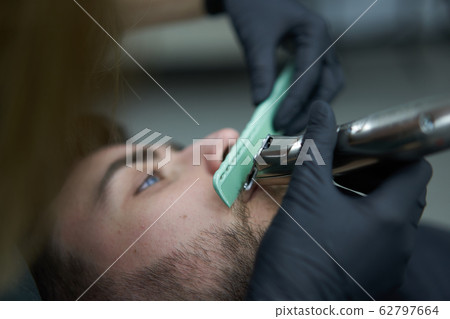 Young beautiful caucasian woman hairdresser cuts Young beautiful caucasian woman hairdresser cuts 62797664