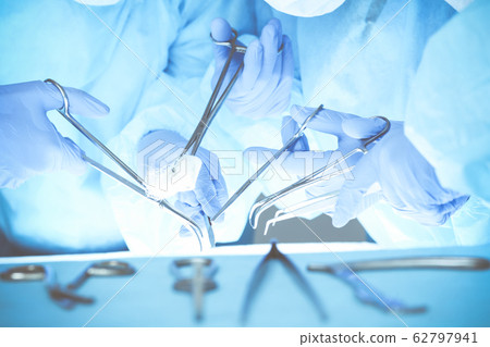 Close-up of medical team performing operation. Group of surgeons at work are busy of patient. Medicine, veterinary or healthcare and emergency in hospital Close-up of medical team performing operation. Group of surgeons at work are busy of patient. Medicine, veterinary or healthcare and emergency in hospital 62797941