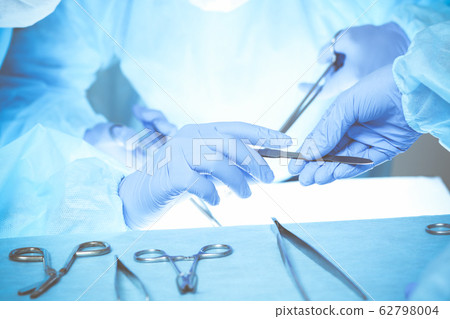 Close-up of medical team performing operation. Group of surgeons at work are busy of patient. Medicine, veterinary or healthcare and emergency in hospital Close-up of medical team performing operation. Group of surgeons at work are busy of patient. Medicine, veterinary or healthcare and emergency in hospital 62798004