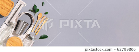Sustainable lifestyle. Zero waste, plastic free shopping concept. Cotton bags, glass jar, bottle, metal cup, straws for drinking, bamboo cutlery and boxes on gray background. Banner Sustainable lifestyle. Zero waste, plastic free shopping concept. Cotton bags, glass jar, bottle, metal cup, straws for drinking, bamboo cutlery and boxes on gray background. Banner 62799806