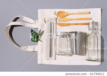 Fabric bags, glass jars, metal straws, bamboo cutlery on grey background with copy space. Eco friendly and reuse concept. Top view. Flat lay. Zero waste concept. 62799812