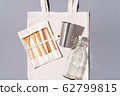 Cotton bags, glass bottle, metal cup, bamboo cutlery on gray background. Sustainable lifestyle. Zero waste, plastic free shopping concept. 62799815
