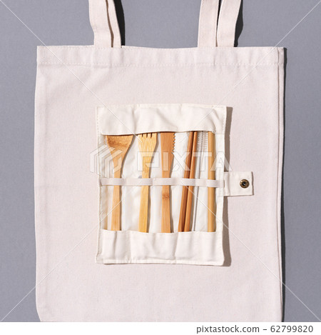 Eco friendly bamboo cutlery set, canvas shopping bag on grey background. Zero waste, plastic free concept Eco friendly bamboo cutlery set, canvas shopping bag on grey background. Zero waste, plastic free concept 62799820