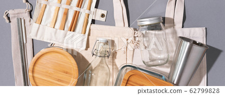 Cotton bags, glass jar, bottle, metal cup, straws for drinking, bamboo cutlery and boxes on gray background. Sustainable lifestyle. Zero waste, plastic free shopping concept. 62799828