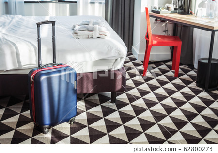 suitcase stands by the bed in the hotel room 62800273