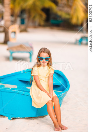Adorable little girl on boat on white beach 62800701