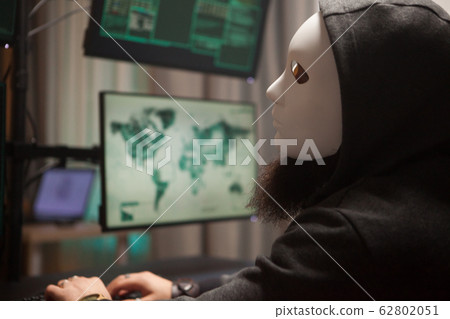 Bearded hacker with a hoodie wearing a white mask 62802051
