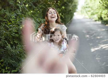 Happy mother and daughter riding motorcycle Happy mother and daughter riding motorcycle 62804403