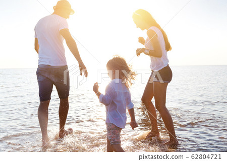 Happy family walking in sea water Happy family walking in sea water 62804721