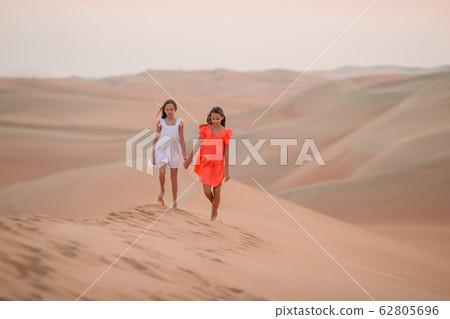 Girls among dunes in Rub al-Khali desert in United Arab Emirates 62805696