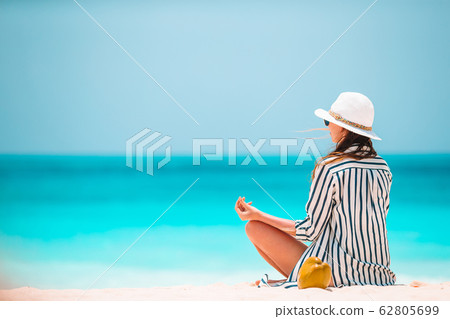 Body of beautiful woman in a meditation on the beach Body of beautiful woman in a meditation on the beach 62805699