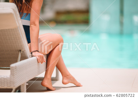 Woman sunbathing on a lounger at tropical resort Woman sunbathing on a lounger at tropical resort 62805722