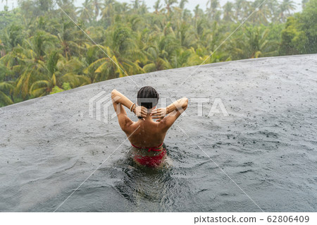Tanned female tourist standing in the water 62806409