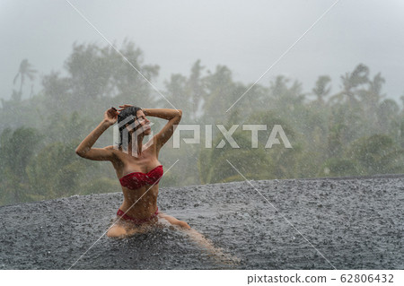 Cute tanned Caucasian girl bathing in the rain 62806432