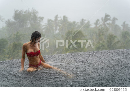 Relaxed female tourist sitting in a swimming pool 62806433