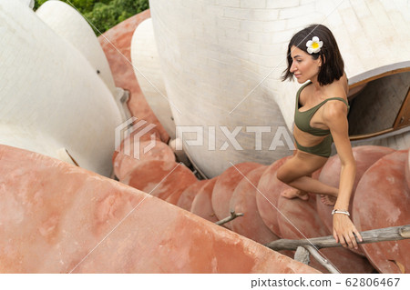 Dreamy barefoot girl leaning on the railing outdoors 62806467