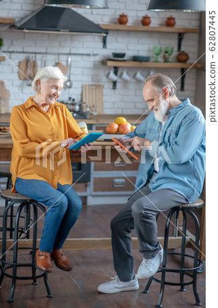 Smiling seniors enjoying using their new tablets Smiling seniors enjoying using their new tablets 62807445