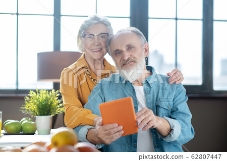 Elderly man showing his wife how to use a tablet Elderly man showing his wife how to use a tablet 62807447