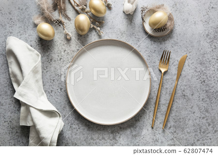 Elegant easter table setting with golden eggs Elegant easter table setting with golden eggs 62807474