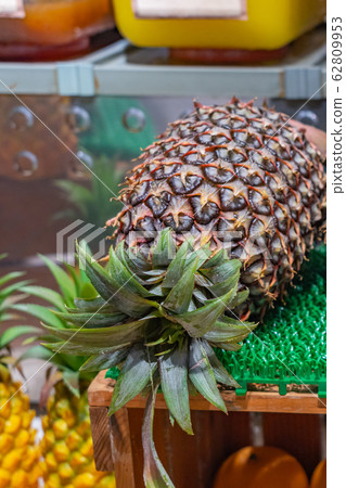 Closeup photo of fresh pineapple at juice and fruit stand 62809953