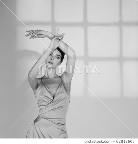 Beautiful woman pose in studio in classic dress 62812603