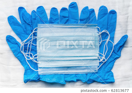 Lot medical respiratory face masks on blue gloves as background. Global pandemic insurance and airborne diseases, influenza, SARS 62813677