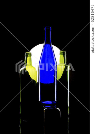 Still life with glass bottles on a light circle Still life with glass bottles on a light circle 62816473