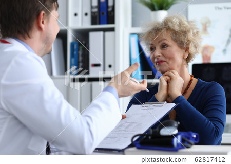 Male doctor asks an elderly lady about health Male doctor asks an elderly lady about health 62817412