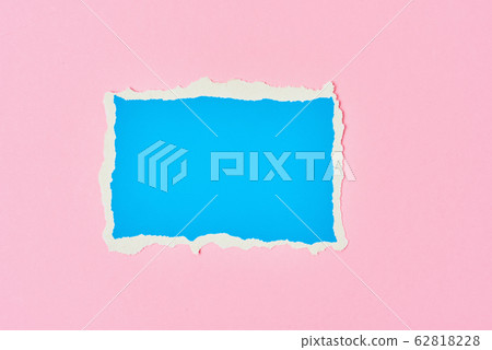 Ripped blue paper torn edge sheet on a pink Ripped blue paper torn edge sheet on a pink 62818228