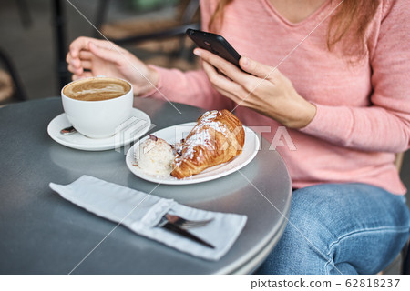 Woman have breakfast in caffe and using Woman have breakfast in caffe and using 62818237