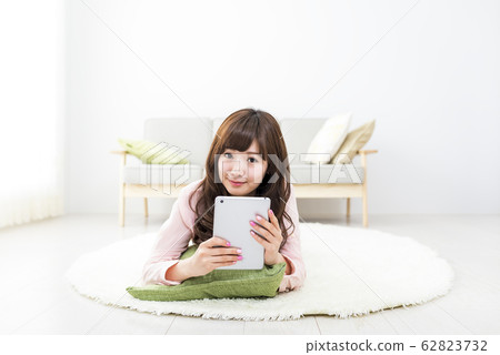 拿著片劑的微笑的婦女 62823732
