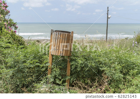 wooden waste bin in a park by sea in a sunny day wooden waste bin in a park by sea in a sunny day 62825143
